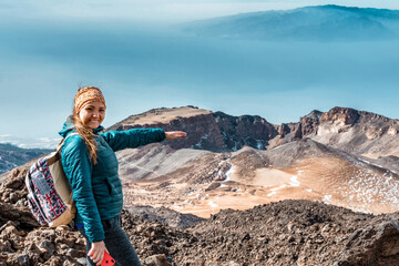 Young woman at the top of El Teide volcano in Tenerife or mountain looking down the valley with...