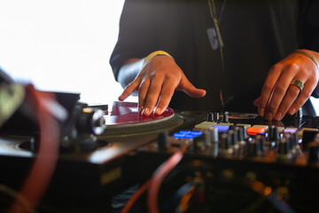 Dj girl scratches vinyl record with music on hip hop battle event in bar.Professional female disc jockey scratching analog records.Retro djs setup on concert stage.Pro audio equipment in nightclub