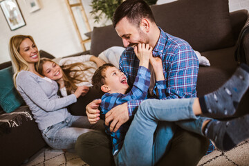 Happy family with kids playing at home. Family sitting on floor and playing together.