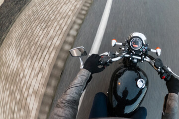 Driving a vintage old black motorbike on a straight asphalt tarmac road highway
