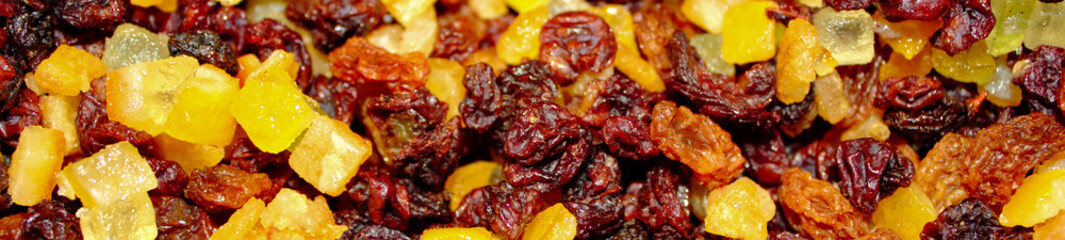panoramic close up of dried  red and yellow raisins, currants, sultanas, mixed orange , lemon and lime peel, and zest, cranberries, and suet . Ingredients for mince meat for pies and Christmas cake.