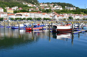 Harbor and coastal village with galician fishing vessels and sailing boats at famous Rias Baixas in Galicia Region. Muros, A Coruña, Spain. - obrazy, fototapety, plakaty