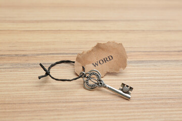 Vintage key with tag on wooden table. Keyword concept