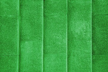 Vintage exterior green color cement wall background with textured vertical lines surface.