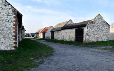 Fototapeta na wymiar Kamienne stodoły z końca XIX i początku XX w Zarkach w promieniach zachodzącego słońca