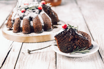  Piece of christmas chocolate cake garnished with berries and rosemary on a plate