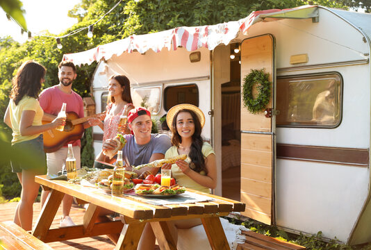 Happy Friends With Drinks And Food Near Trailer. Camping Season