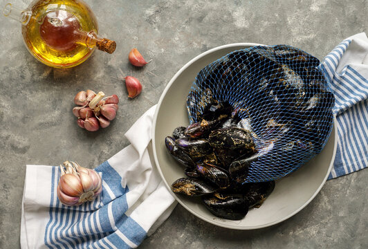 Fresh raw sea mussels with garlic ready to be cooked