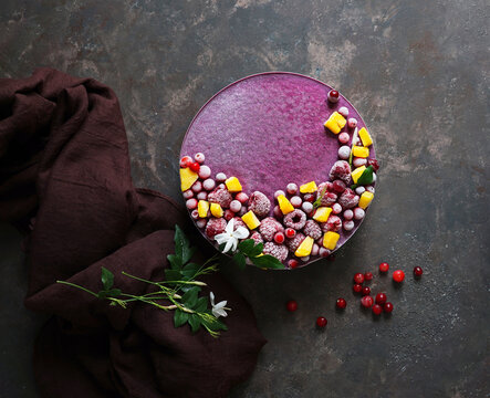 Vegan raw cake with lemon, cranberry, raspberry and blueberry, banan, cashew cream, coconut butter and coconut milk