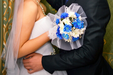 Groom's hand hugs the bride's waist close-up