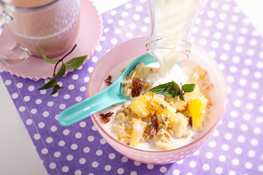 Muesli with oats, pineapple, apple, oranges, persimmon and milk