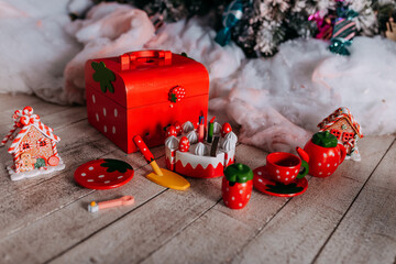 Eco-friendly christmas gifts for kids under the tree. Christmas tree decorated with toys and colorful candy canes and sweets. Present boxes under the christmas tree. Wooden toys for girls.