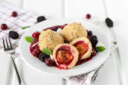 Damson dumplings in a pool of berry sauce