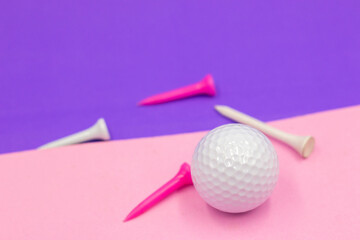 Golf ball and tee are on purple background