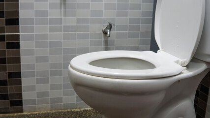 Fototapeta premium White toilet bowl seat in a modern interior design bathroom with pebble wash tiles floor.