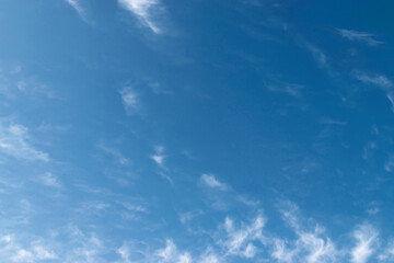 White feathery fluffy clouds on a blue sky, background and texture