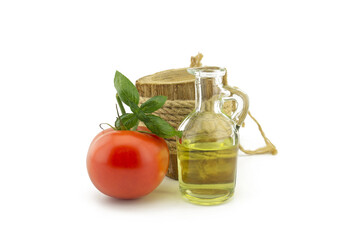Tomato and basil leaf and oil in decanter on white