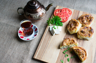 Delicious pies on wooden background with cheese,tomato,parsley, cheese and tea