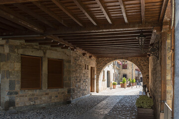 Cobblestone walkway tunnel with an arched entryway in Potes, Cantabria, Spain
