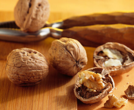 Walnuts (Juglans regia), whole and opened, with a nutcracker