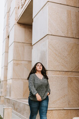 Portrait of a young adult girl on the background of a modern building