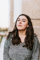 Portrait of a young adult girl on the background of a modern building