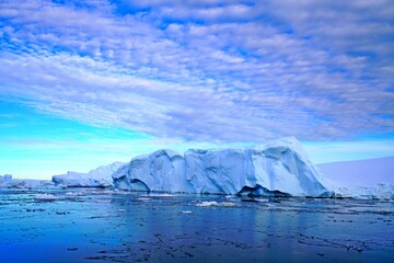 The blue sky shows radial clouds, icebergs and deep blue sea. These are the characteristics of...