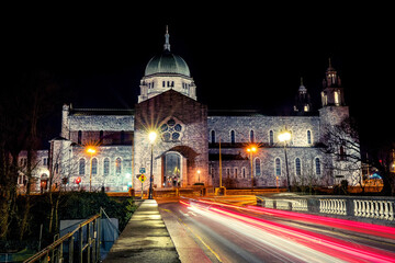 Fototapeta na wymiar Galway cathedral building at night with car red light trails. Black sky, Nobody. Ireland. Popular town landmark