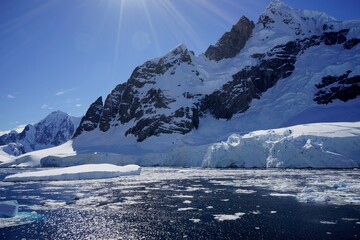 The sun hung in the sky, and the melting snow from the icebergs exposed the rocks. Summer in Antarctica seems very hot.