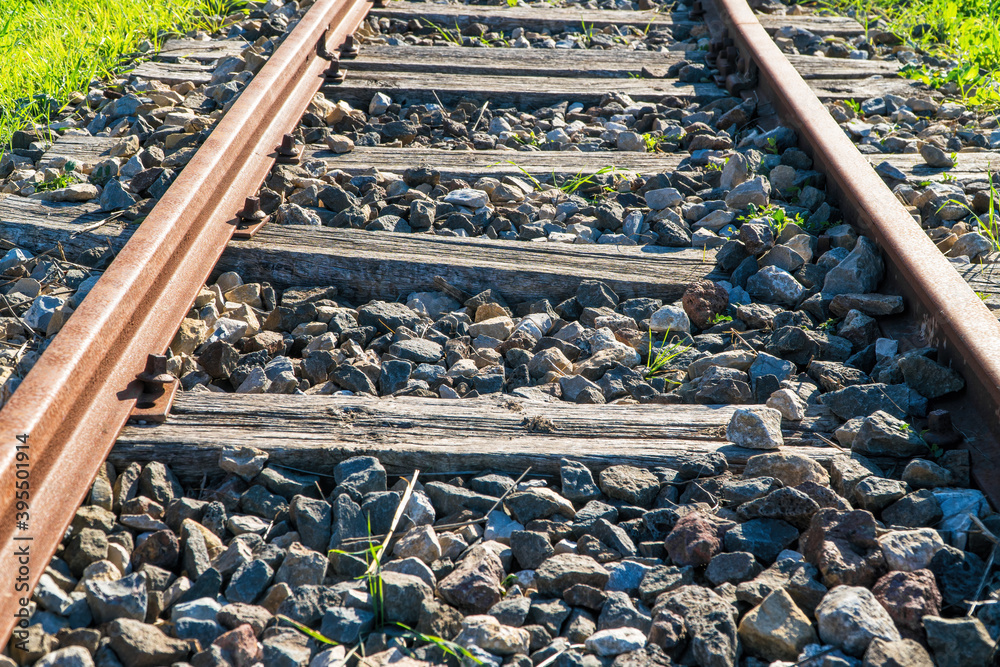 Wall mural old rails with wooden slats on rocky floor