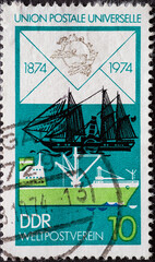 GERMANY, DDR - CIRCA 1974 : a postage stamp from Germany, GDR showing a modern cargo ship and old...