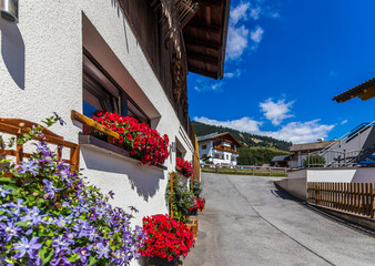 A typical village in the Alps with flowers in front of the houses.