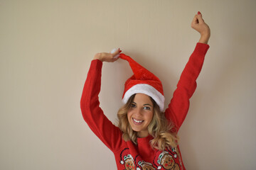 Happy woman, wearing a red sweater and a Christmas hat.