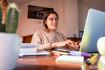 Young female student using her laptop, studying at home. Home concept.