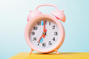 Alarm clock on a table with arrows in the form of toothbrushes. The concept is time to brush your teeth