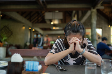 Woman praying, hands folded in prayer
