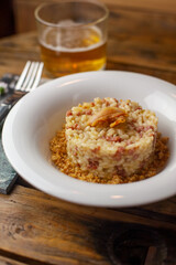 risotto alla birra e salsiccia su tavolo di legno vista laterale