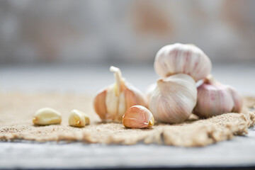 Garlic cloves and bulbs on wooden cutting board