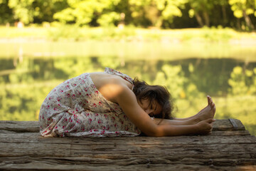 A young beautiful woman practicing yoga in a park in late summer. Health lifestyle concept stock photo.