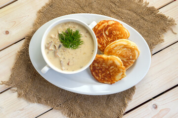 Fritters with mushroom sauce. Traditional Slavic pancakes with fat mushroom and flour sauce.
