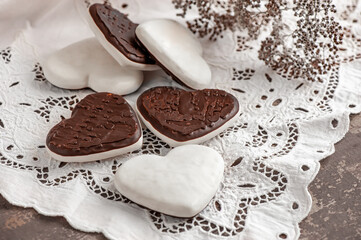 gingerbread hearts in white icing and chocolate on a beautiful white napkin. Traditional Christmas gingerbread cookies