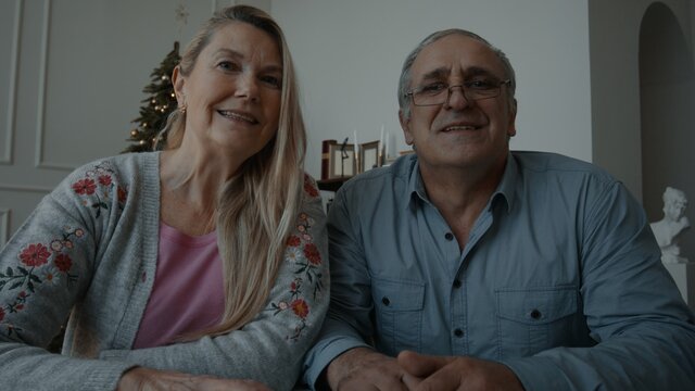 POV webcam view, Senior adult Caucasian couple having a video call with friends or family on Christmas eve. Holidays celebration during COVID-19 Coronavirus lockdown