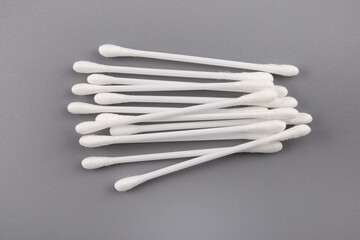 Cotton white swabs on gray background. Top view.Сoncept of using in cosmetic procedures,harm for ears.