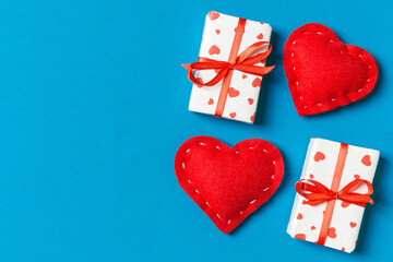 Top view of gift boxes and red textile hearts on colorful background. St Valentine's day concept with copy space