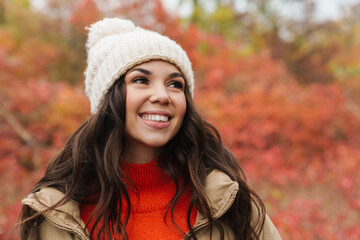 Beautiful happy woman smiling while strolling in autumn forest