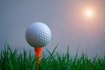 Golf ball on tee in beautiful golf course at sunset background