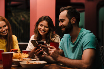 pGroup of happy smiling friends with smartphones