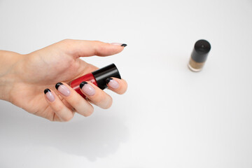 girl holding nail Polish in her hand. photo on a white background