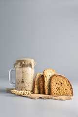 Active rye sourdough for bread and slices of natural whole grain bread