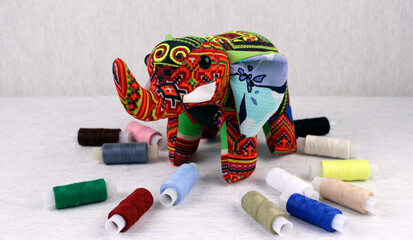 Fototapeta na wymiar Toy elephant on a white background with multi-colored threads